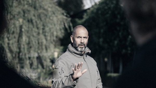 Rico Briedjal in gesprek, buiten, van opzij gezien