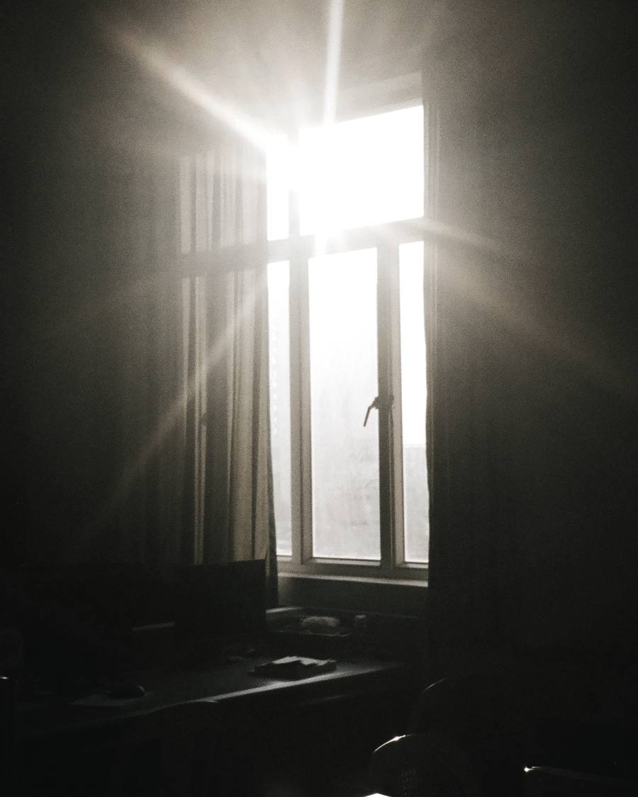 Een donkere kamer waar het eerste licht van de dag door het raam komt